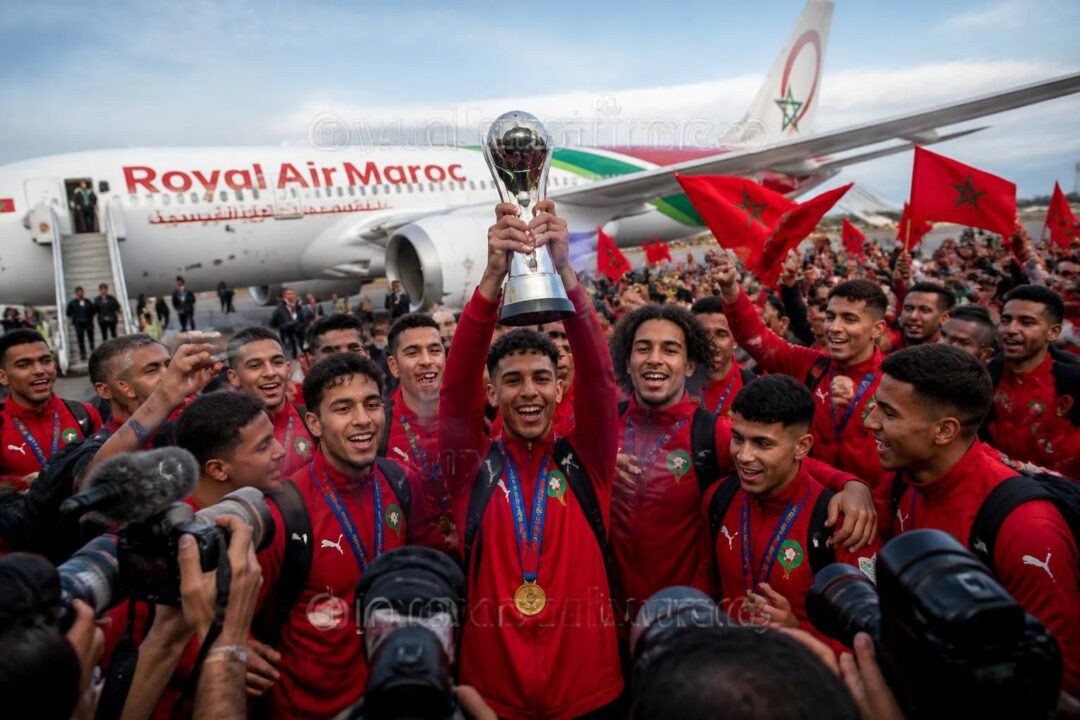 découvrez le retour triomphal des héros de l'équipe u20 du maroc à santiago, célébrant leur victoire au mondial avec le trophée en main.